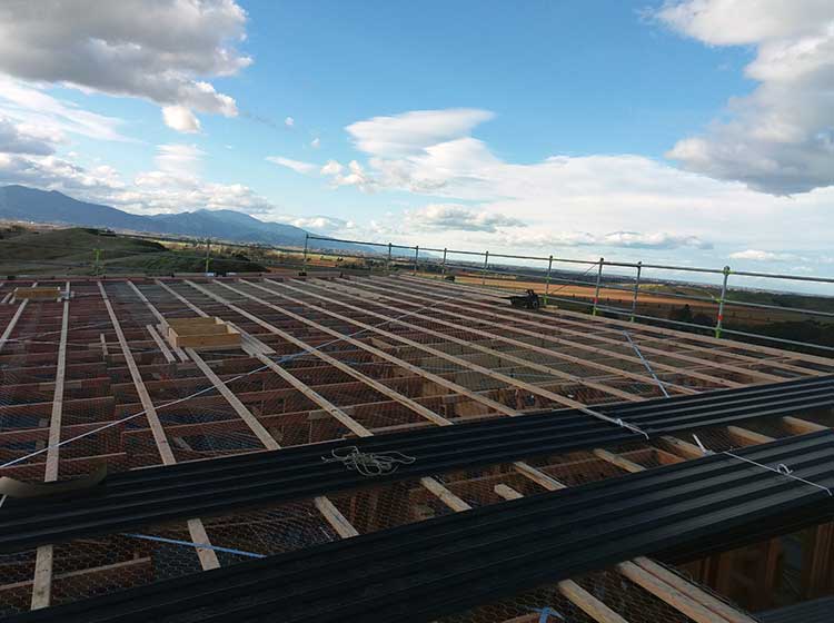 Long-run iron roof installation in progress on a rural Canterbury building