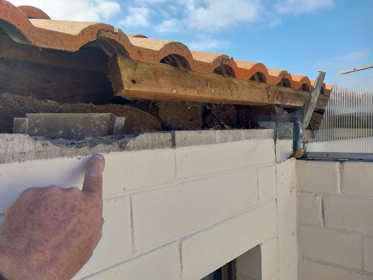 Roof opened up showing the rotted timber and failed internal gutter beneath