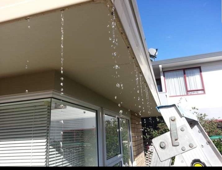 Water streaming over a fascia line during rain because the internal gutter has backed up