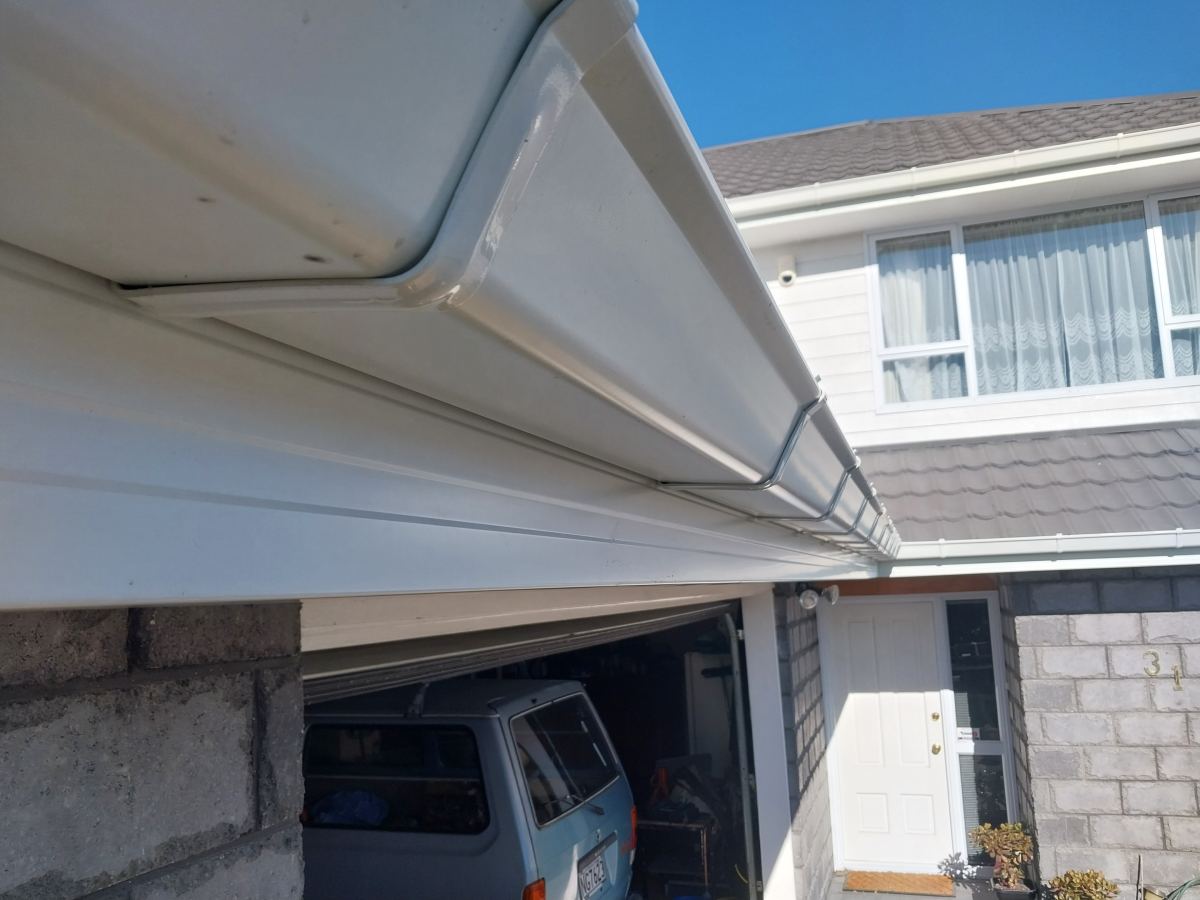 Completed white fascia and gutter line above a garage