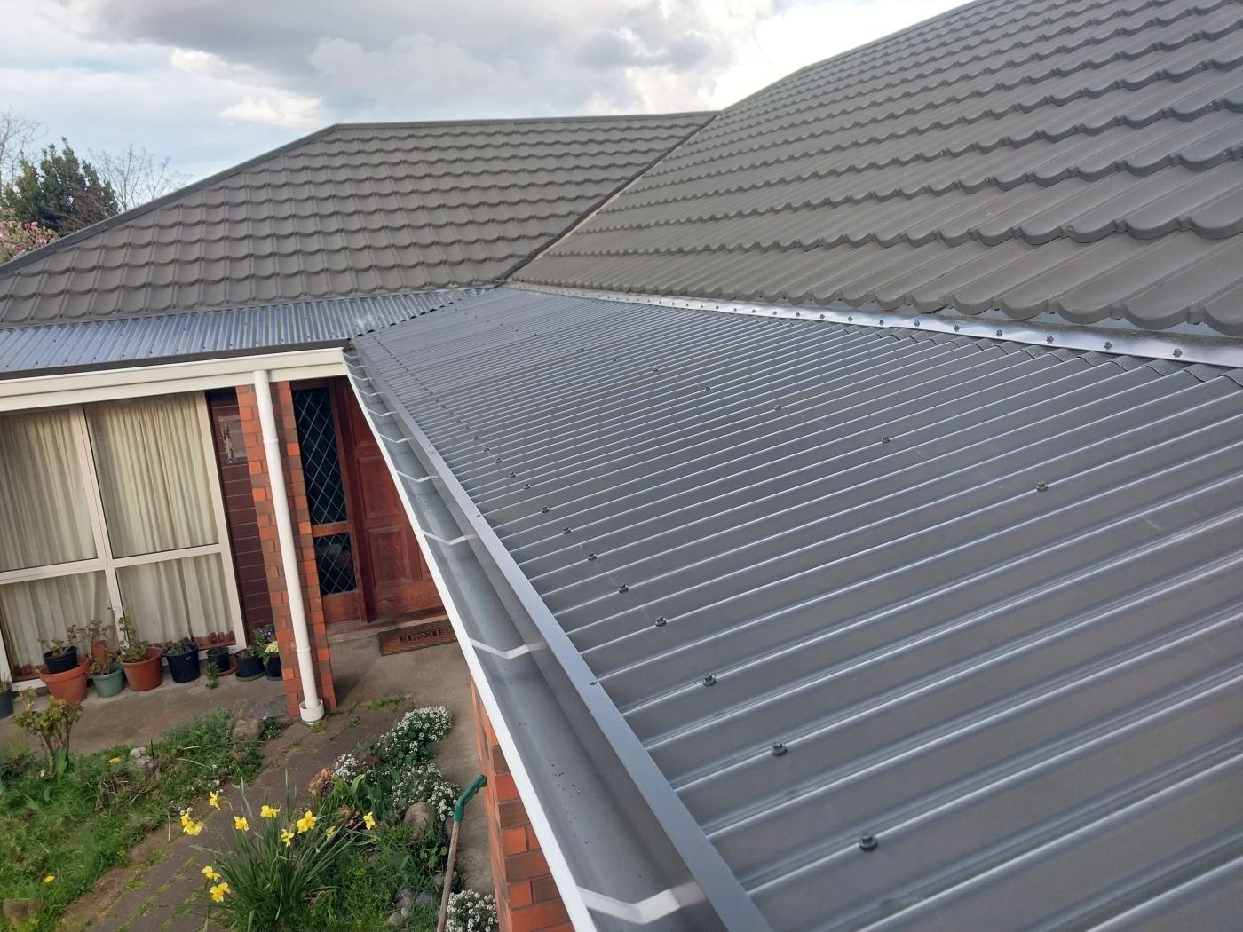 Completed roof section and gutter line seen from above the tile roof