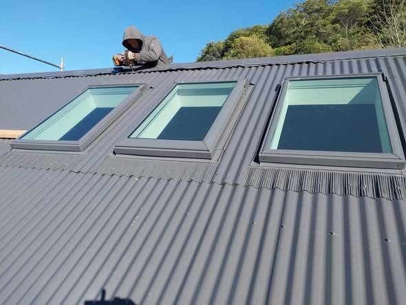 Three Velux roof windows flashed into a new steel roof