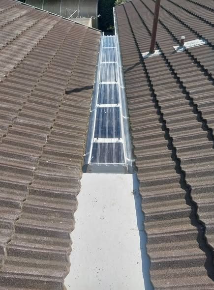 Clear roofing sheet installed over a converted internal gutter