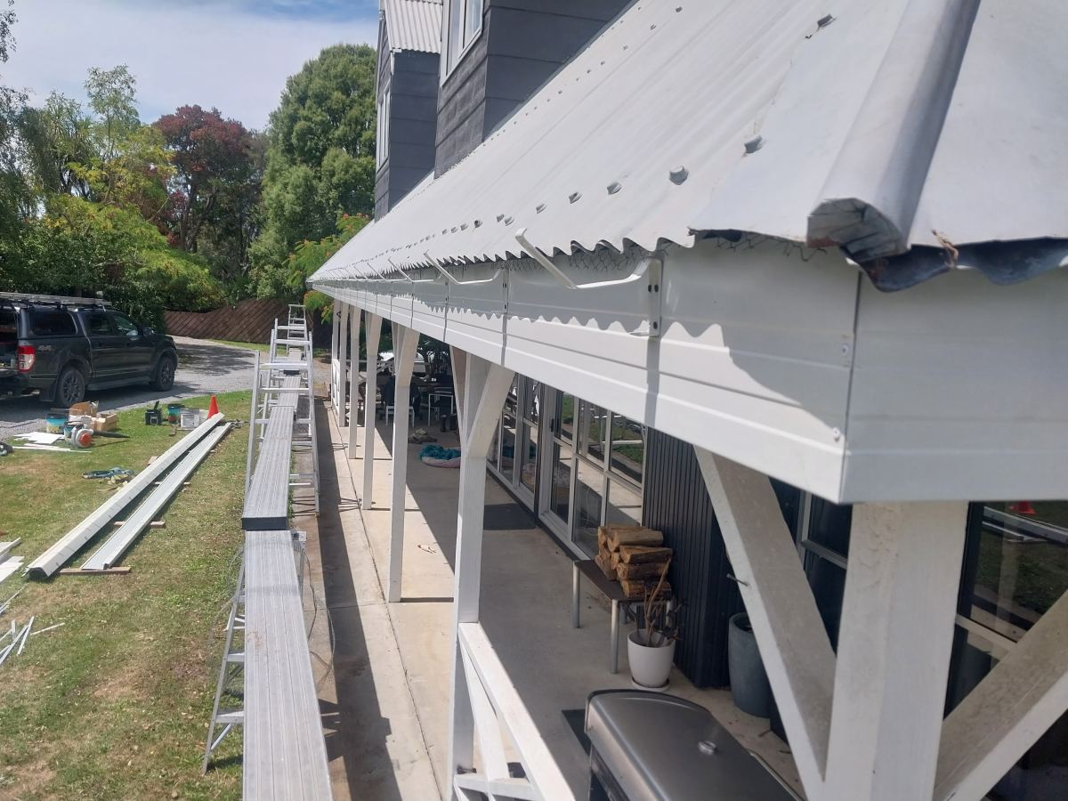 New white fascia being fitted along a veranda roofline